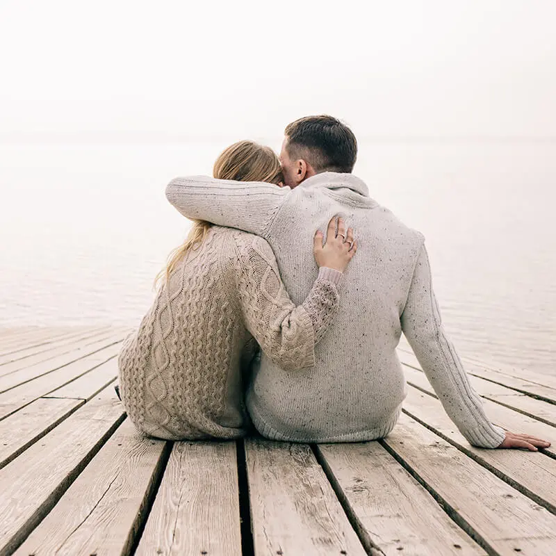 Couple hugging by a lake