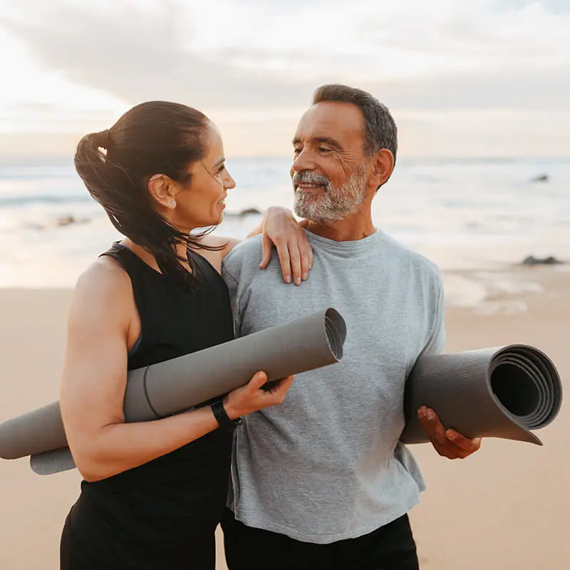 Couple doing yoga at the beach