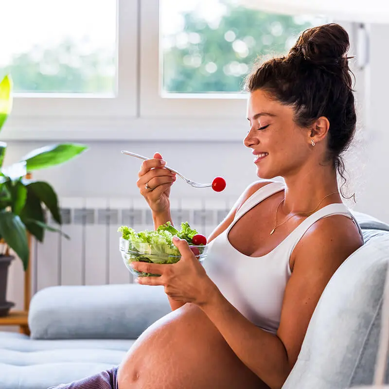 Pregnant woman eating a salad